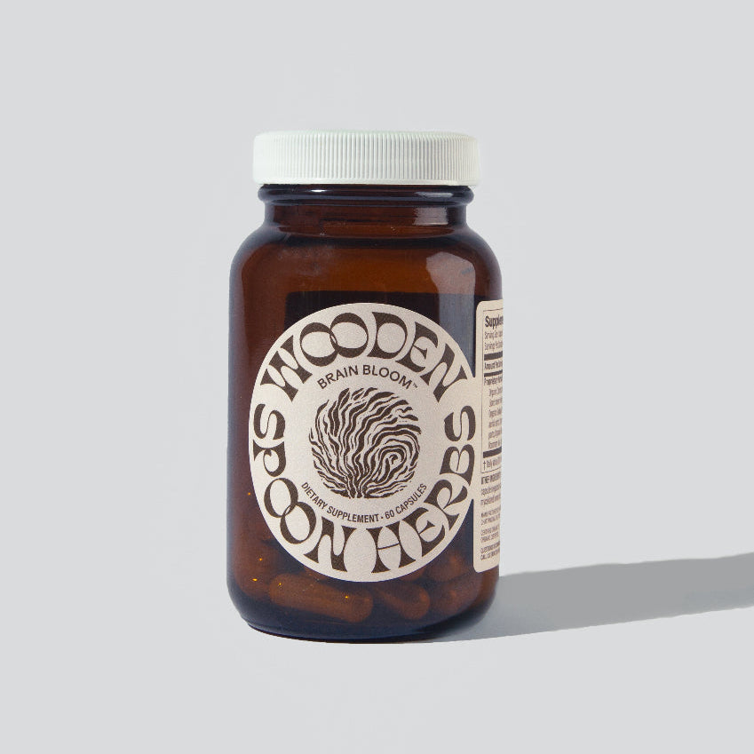 A bottle of Brain Bloom herbal supplement powder with the label Wooden Spoon Herbs.