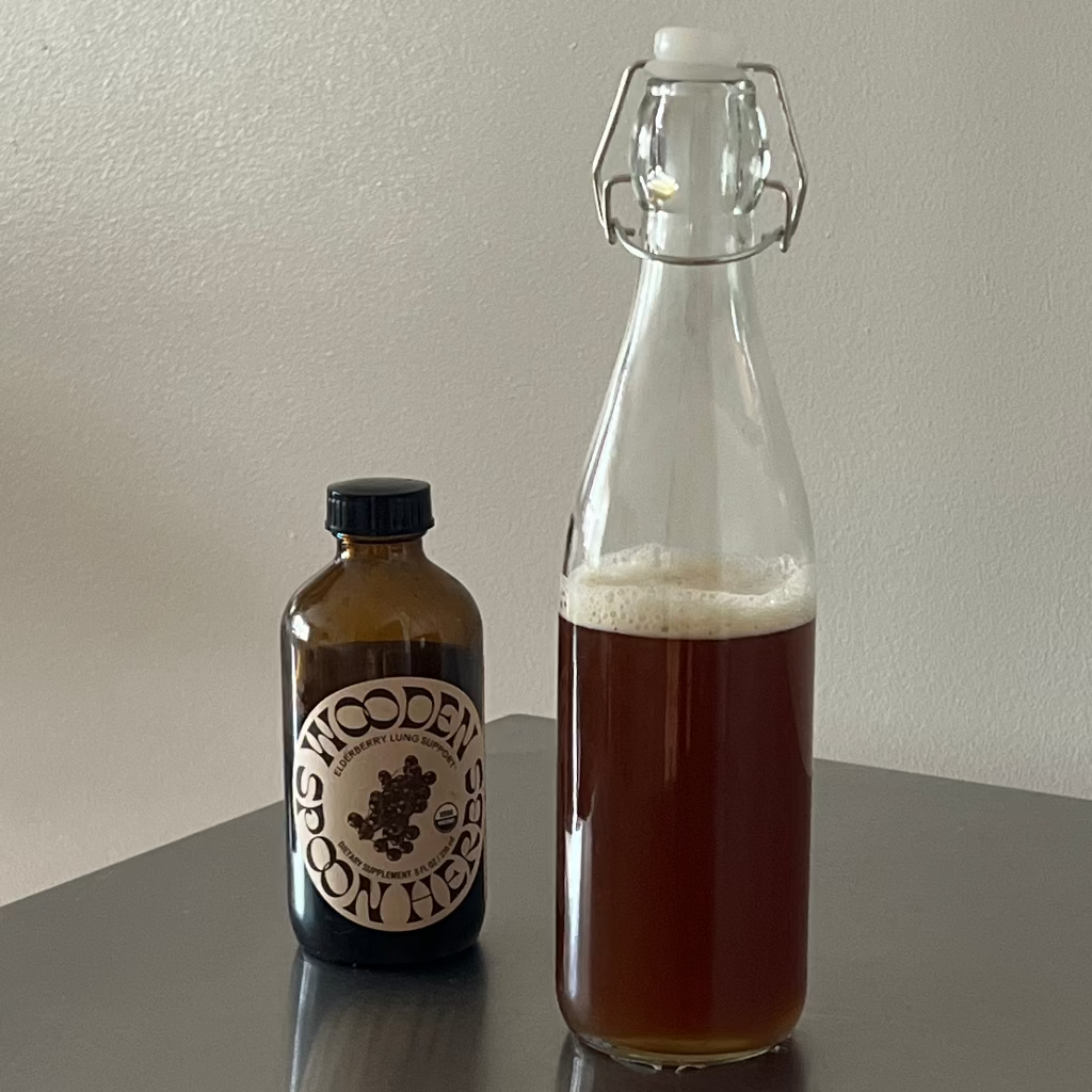 Two bottles, one with a label and the other clear, on a reflective surface.