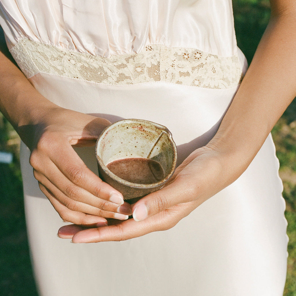 Lemon Ginger Immune Support in a cup being held with two hands.