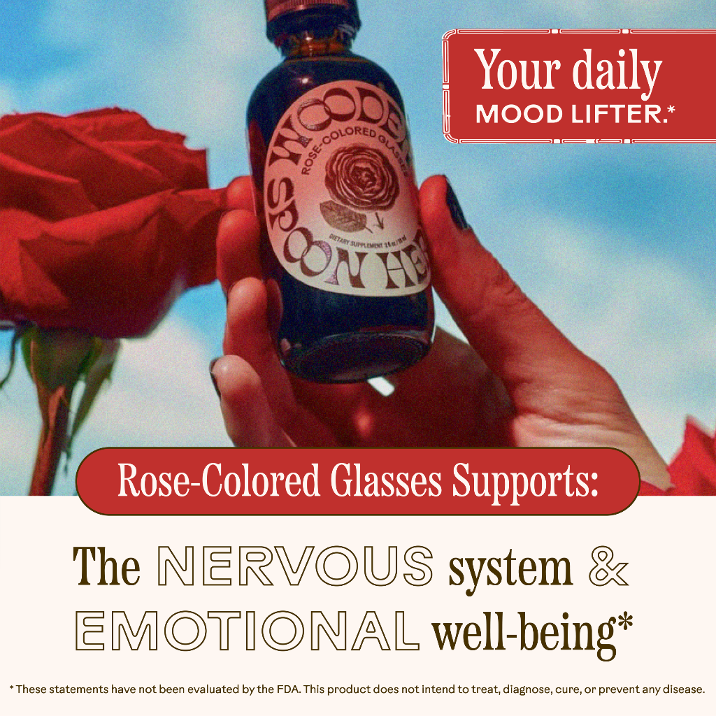 Hand holding a bottle labeled 'Rose-Colored Spoonful' with text about mood support and rose-colored glasses.