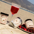 Magic Mag in Tart Cherry on a beach with cherries and a cocktail.