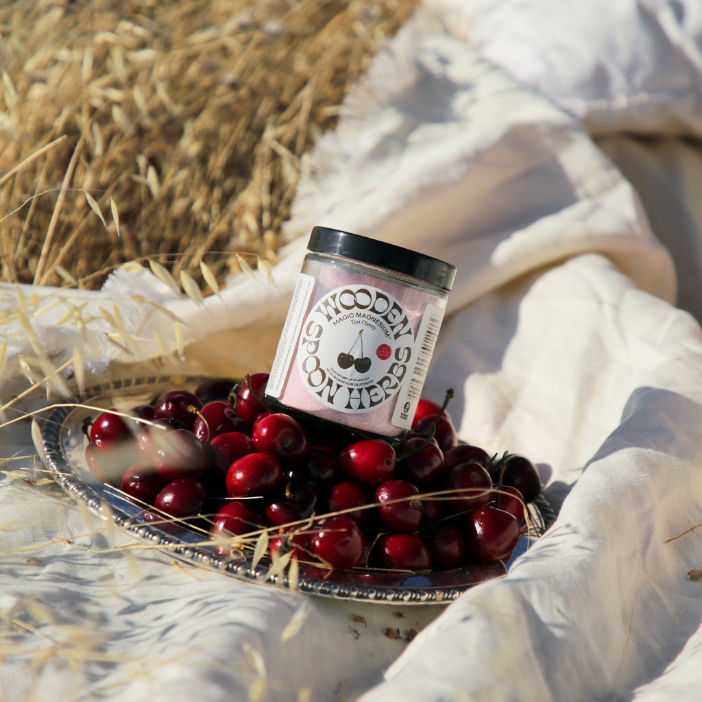 Jar of Magic Mag Cherry with cherries on a plate outdoors