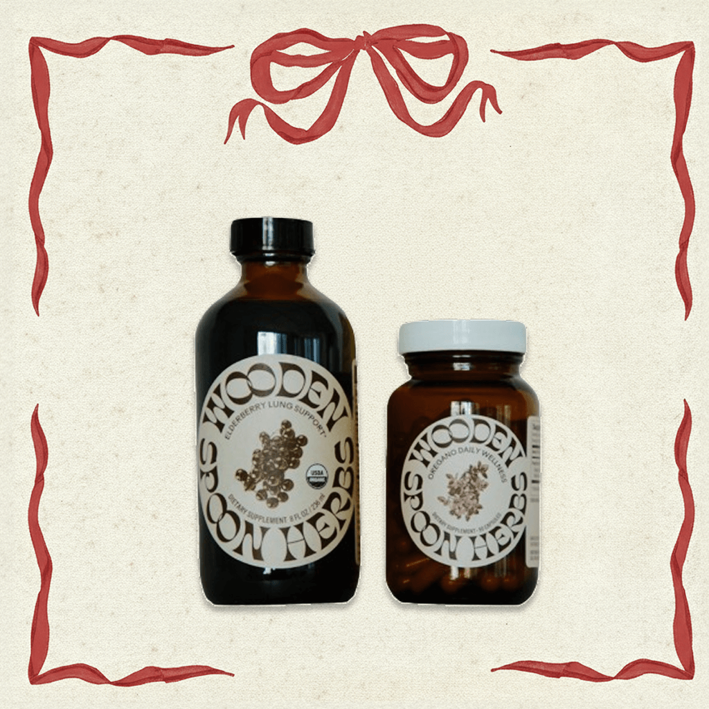 Two bottles of Wooden Spoon Herbs on a decorative background with red ribbons.